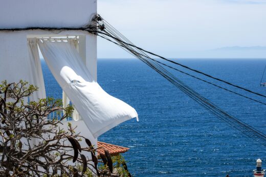 Power Lines on Wall and Draper in Window of Building on Sea Shore